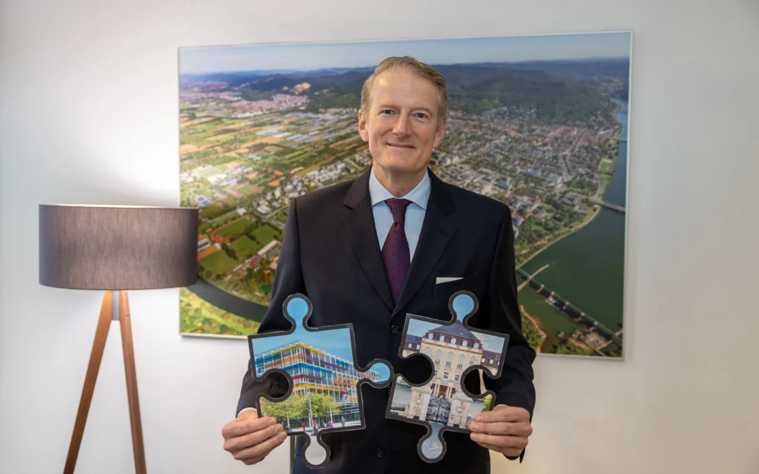 Professor Dr. Hanns-Peter Knaebel fügt die Puzzleteile, die symbolisch für die Unikliniken in Heidelberg und Mannheim stehen, im Verbundsmodell zusammen. Bild: Cheesy Photo