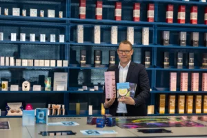 Tobias Laubmann, Abteilungsleiter im Print Media Center, zeigt bekannte Produktverpackungen, die am Standort produziert werden.
